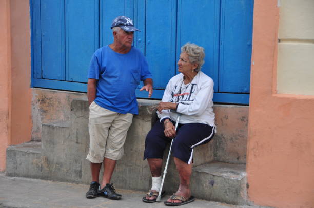 So much of Cuban life takes place on the city streets: negotiating with vendors, gossiping and board games with neighbors, playing music for passersby, etc. Here a couple of neighbours are chatting. Photos taken in Camaguey in January 2017.