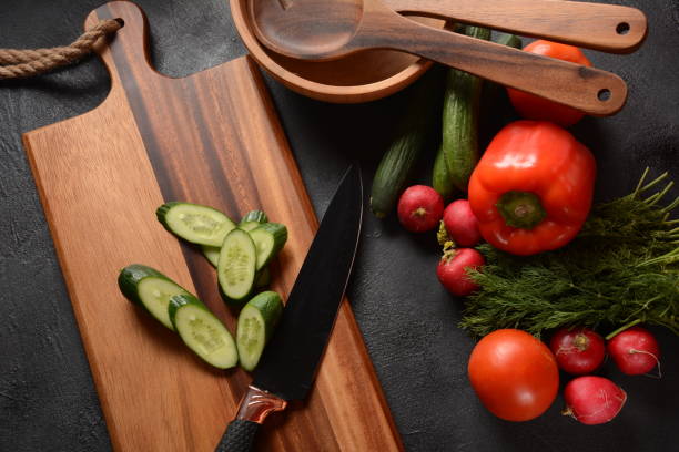 istock Fresh cucumbers and knife on a cutting board. Preparing, cooking food concept 1226729502
