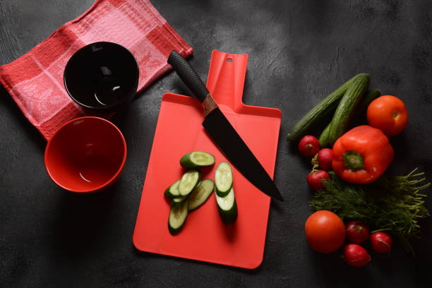 istock Fresh cucumbers and knife on a cutting board. Preparing, cooking food concept 1226729529