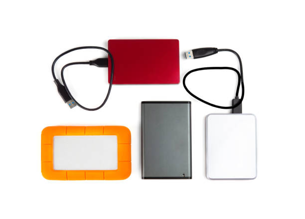 istock Four portable hard disk drives of different colors and sizes isolated on white, top view. 1226729742