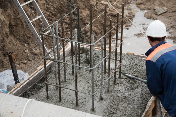 istock The process of compacting and smoothing fresh concrete. Concrete is poured into the formwork with rebar. Workers level the concrete surface. 1226730102