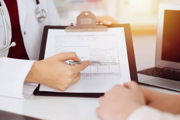 istock Unknown woman-doctor consulting patient and using clipboard with a medication history record in sunny room. Medicine concept 1226732372