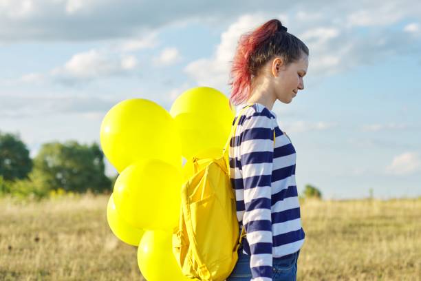 profile portrait of happy teenager girl 15 years old with yellow balloons - teenager 14 15 years 13 14 years cheerful imagens e fotografias de stock