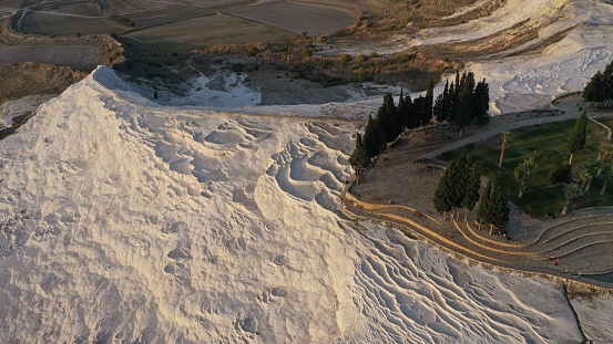 Aerial view of observation deck and thermal pools hot springs tavertine terraces of Pamukkale natural park, white cotton castle, snow white mountains with carbonate mineral milky pools, Turkey