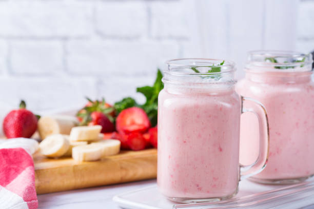 smoothie rose avec banane et fraise pour un régime sain et végétalien - smoothie banana smoothie milk shake banana photos et images de collection