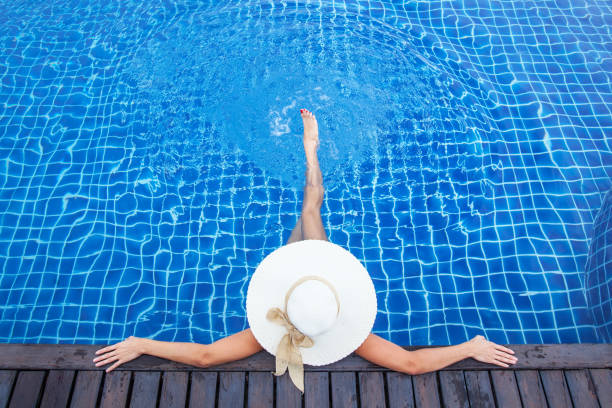istock Woman sunbathing by the pool 1226735367