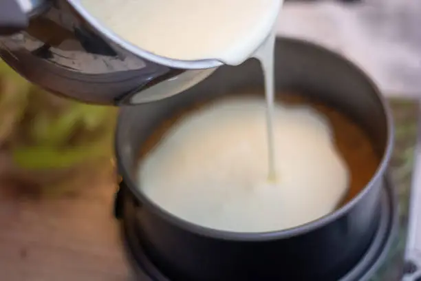 Making a new York cheesecake or classic cheesecake: add the cheese cream on the cookie base
