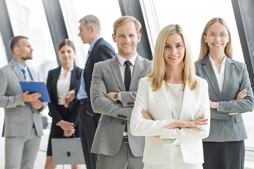 Portrait of businessteam standing in office, smiling, senior executive people in focus