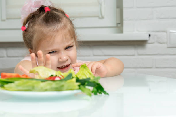 kleines mädchen lehnt gemüse ab - eating obsessive child toddler stock-fotos und bilder