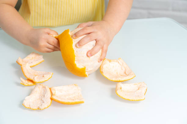 istock little girl peels grapefruit 1226744789