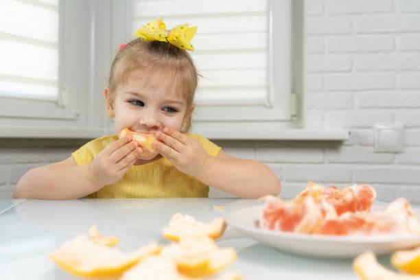 istock little girl eating grapefruit 1226745413