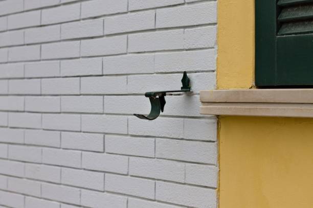 Iron shutter stop detail in a white brick wall (Pesaro, Italy, Europe)
