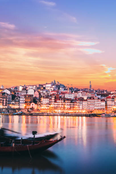 vertical landscape view with a rabelo boat and douro river in the ribeira in oporto city at sunset - vinho do porto imagens e fotografias de stock