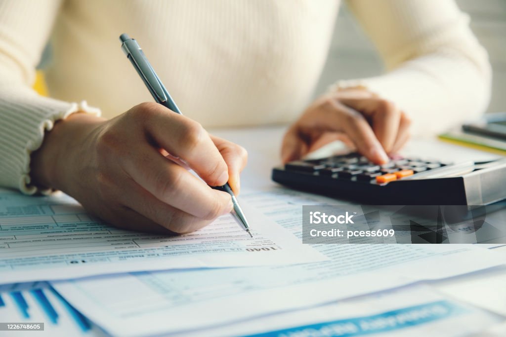 Closeup woman filling form of Individual Income Tax Return, Tax Stock Photo