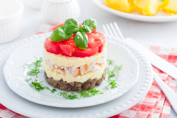 istock Festive layered salad with fried champignons, smoked chicken, eggs and cheese, garnished with fresh tomatoes, selective focus 1226750833