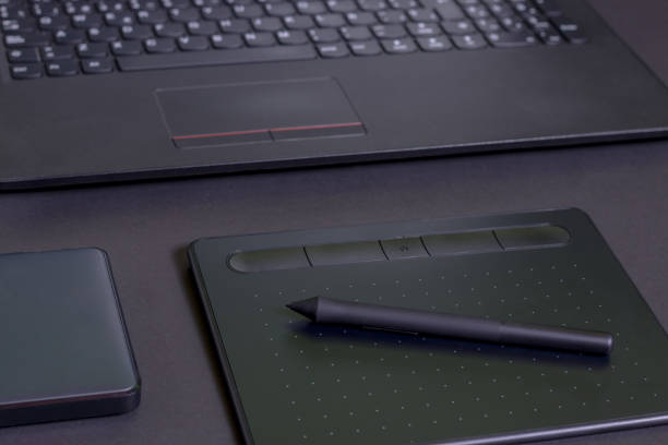istock Pen tablet, with a laptop and a hard drive on a black background 1226752062
