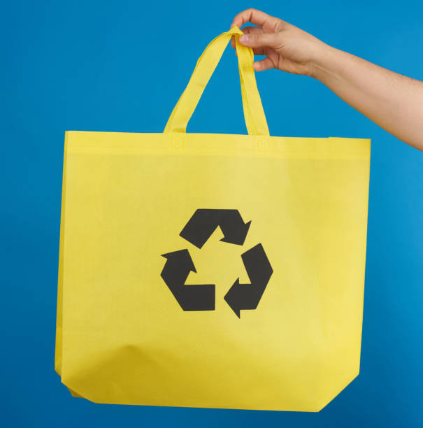 istock woman's hand holds a yellow viscose ecology bag 1226753667