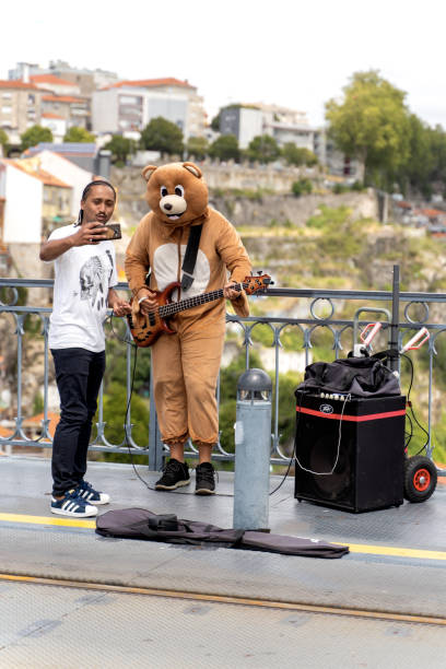 muzyk uliczny z turystą na moście ponte de dom luis i - playing an instrument vertical blurred motion outdoors zdjęcia i obrazy z banku zdjęć