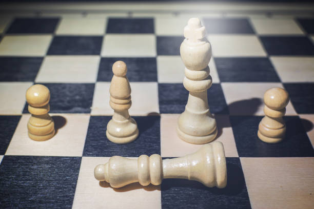istock White queen fallen on the chessboard and behind her the king and other pieces 1226754975