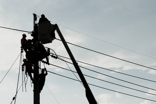 嵐の後に損傷した電力ケーブル線の問題を修復するために電柱を登る電気技師の労働者。電力線サポート、技術のメンテナンスと開発業界の概念 - power line electrician electricity manual worker ストックフォトと画像