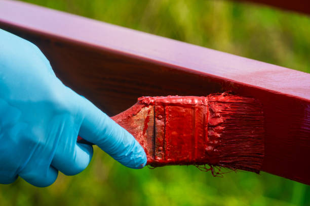 il pittore di case dipinge strutture metalliche. rivestimento protettivo di profili chiusi in acciaio con ossido di ferro primer rosso. - oxide foto e immagini stock