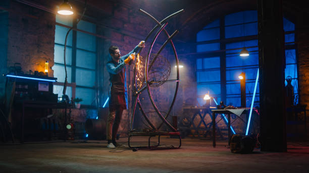 istock Talented Innovative Artist Uses an Angle Grinder to Make an Abstract, Brutal and Expressive Metal Sculpture in a Workshop. Contemporary Fabricator Creating Modern Steel Art. 1226760148