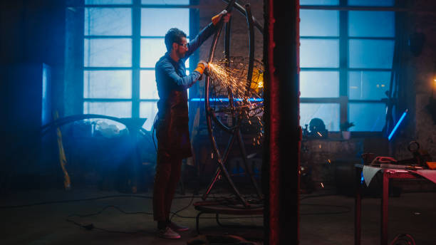istock Talented Innovative Artist Uses an Angle Grinder to Make an Abstract, Brutal and Expressive Metal Sculpture in a Workshop. Contemporary Fabricator Creating Modern Steel Art. 1226760168