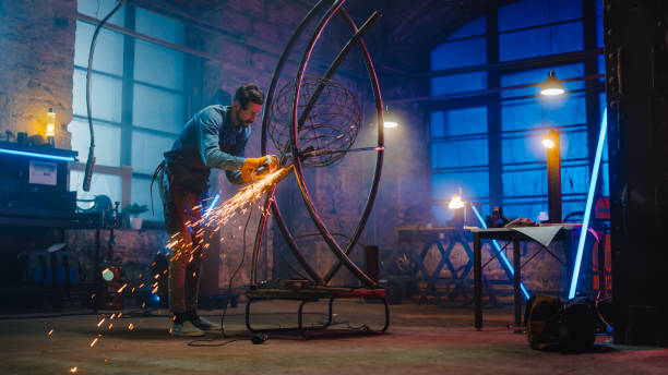 istock Talented Innovative Artist Uses an Angle Grinder to Make an Abstract, Brutal and Expressive Metal Sculpture in a Workshop. Contemporary Fabricator Creating Modern Steel Art. 1226760181
