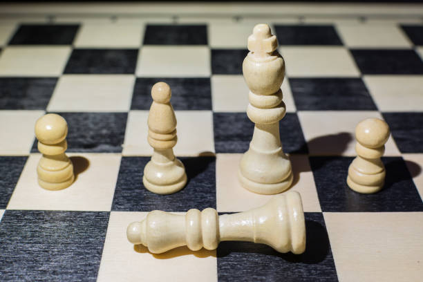 istock White queen fallen on the chessboard and behind her the king and other pieces 1226760202