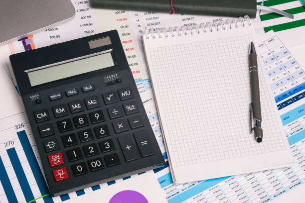 istock Calculator and an empty Notepad page on the office Desk with financial indicators and charts. Top view with a copy of the text input space. Finance and accounting. Company report. 1226760295