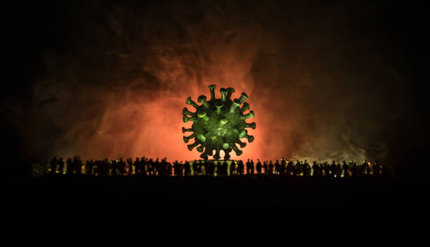 istock Coronavirus 2019-nCov novel coronavirus concept. Crowd looking on big Corona virus model at night with fog and backlight. Creative artwork decoration. Selective focus. 1226762148