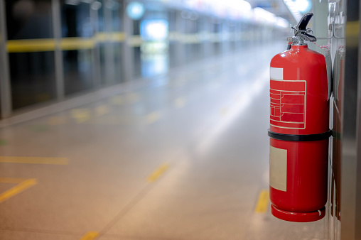 Fire extinguishers hanging on the wall available in fire emergencies at the subway station.