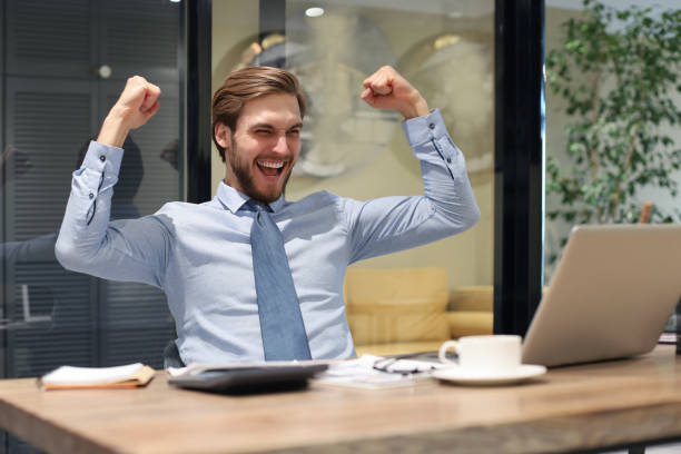 istock Handsome businessman is keeping arms raised and expressing joyful in office. 1226763252