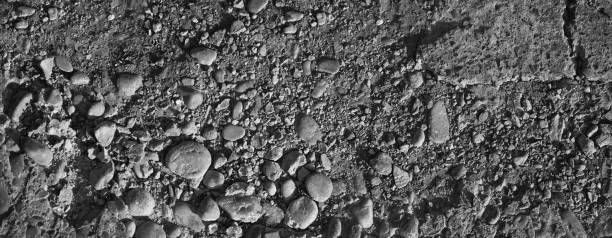 istock Broken crumbling sidewalk made of concrete slab. Black and white stone background. 1226764698