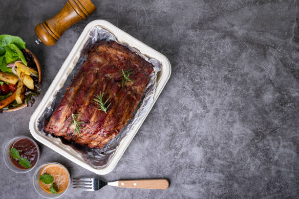 istock Grilled pork ribs with Vegetables and sauces on a drak table. 1226766355