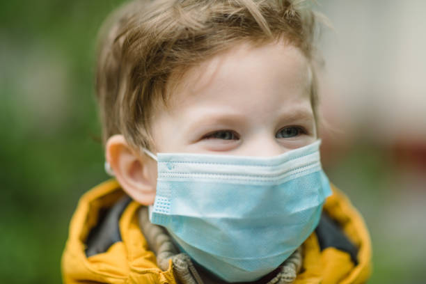 istock Cute little boy smiling behind protective mask outdoors 1226766540