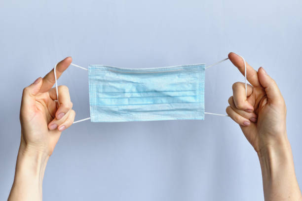 istock Hands holding a mask on a white background - virus protection concept. 1226769354