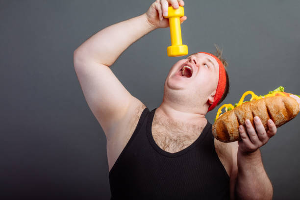 Thick funny guy in sportswear eat small dumbbells