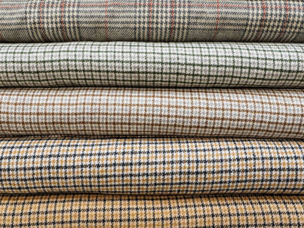 istock Rolls of different checkered fabrics for sewing coats close-up. Samples of different checkered fabrics are on the shelves in the fabric store. Beautiful and fashionable fabrics for ateliers 1226770504