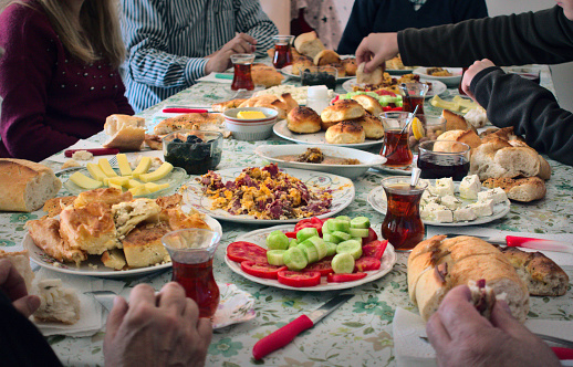 Crowded and hungry Turkish Muslim family having breakfast together (traditional serpme kahvalti) to celebrate Eid-ul-fitr, Feast of Sugar, after the holy month Ramadan