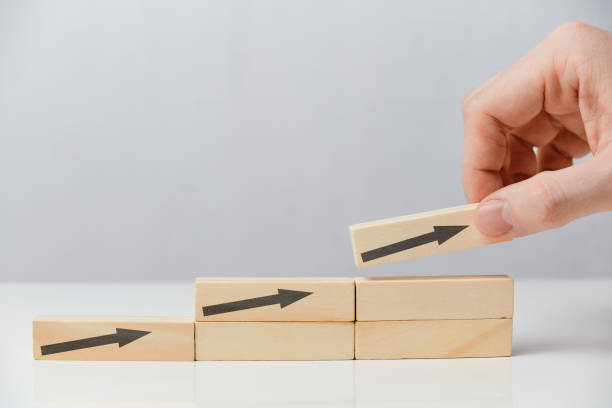 istock Successful business concept - hand puts wooden blocks with arrows on a white background. 1226772454