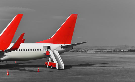 tails of red white passenger airplanes in airport