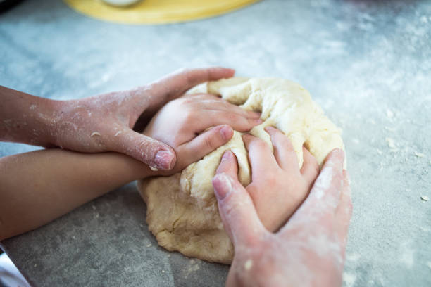 istock Mom and baby make dough from flour 1226774682