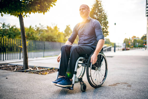 istock Business Professional Rolling Past Camera in Wheelchair 1226774908
