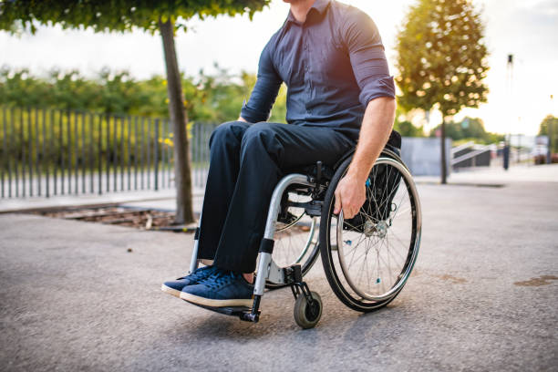 istock Businessman in Mid 20s Rolling Along Pathway in Wheelchair 1226775002
