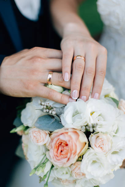 istock Bride and groom holding hands with wedding rings 1226775136
