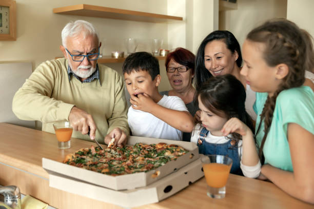 istock Multi-Generation Family Around Kitchen Island is Eating Tasty Pizza. 1226777363