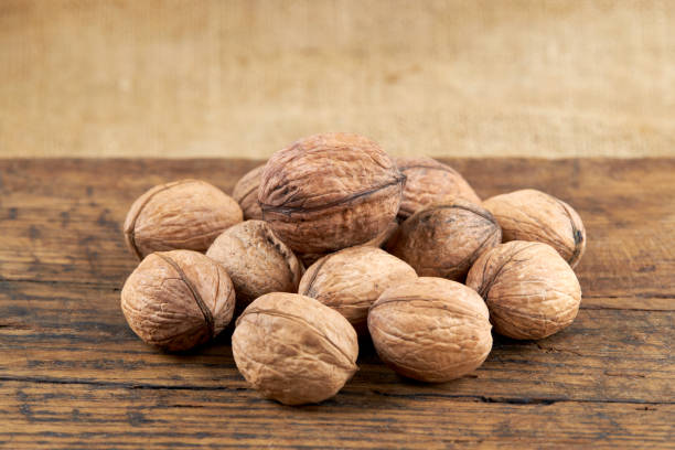 istock group of fresh raw walnuts on a grunge wooden background. rustic and detailed image. 1226777501