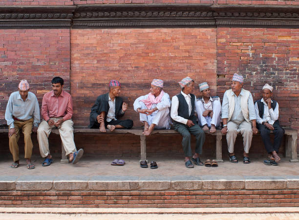 Newar people discussing news at Durbar Square in Patan, Nepal Patan, Nepal - May 10, 2008: Nepalese and Newari men discussing news of today on Durbar Square. Newar people are the historical inhabitants of the Kathmandu Valley and its surrounding areas in Nepal and the creators of its historic heritage and civilisation. patan durbar square stock pictures, royalty-free photos & images