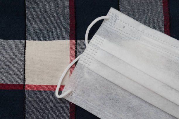 istock Protective face mask on plaid fabric. Brazilian 
